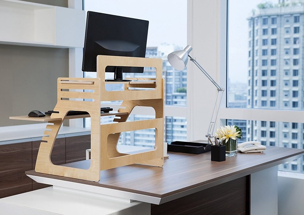 well desk adjustable stand on a desk with a window city view in background